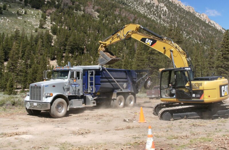 excavator lifting dirt into dump truck
