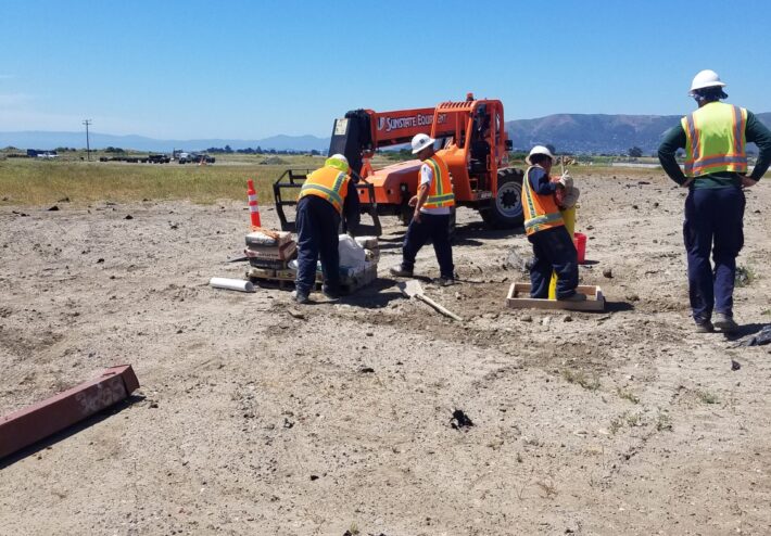 four people working in a sandy area