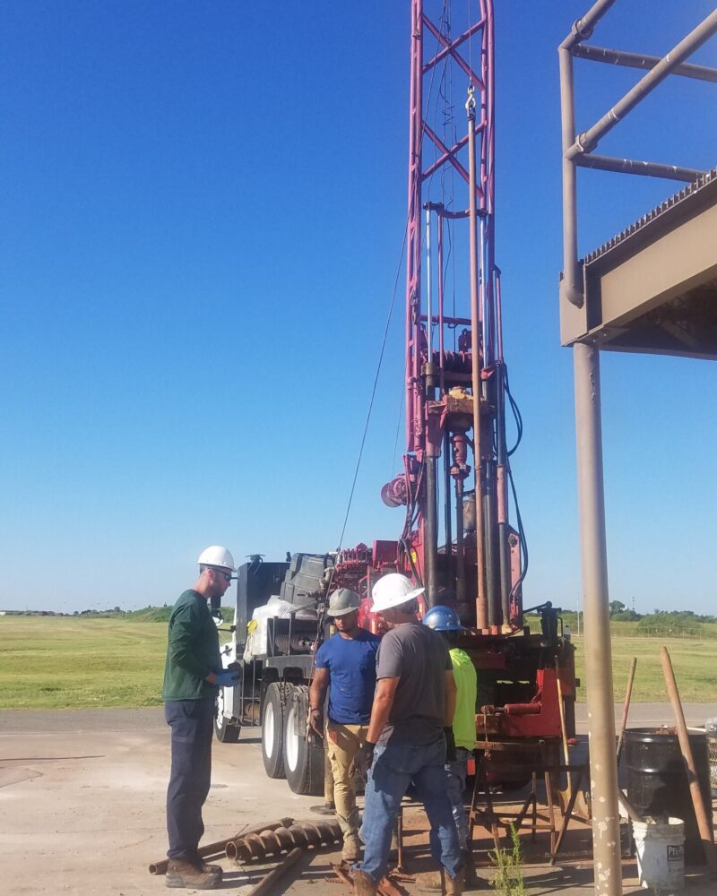 20190724_090535 people talking around a tall drilling equipment