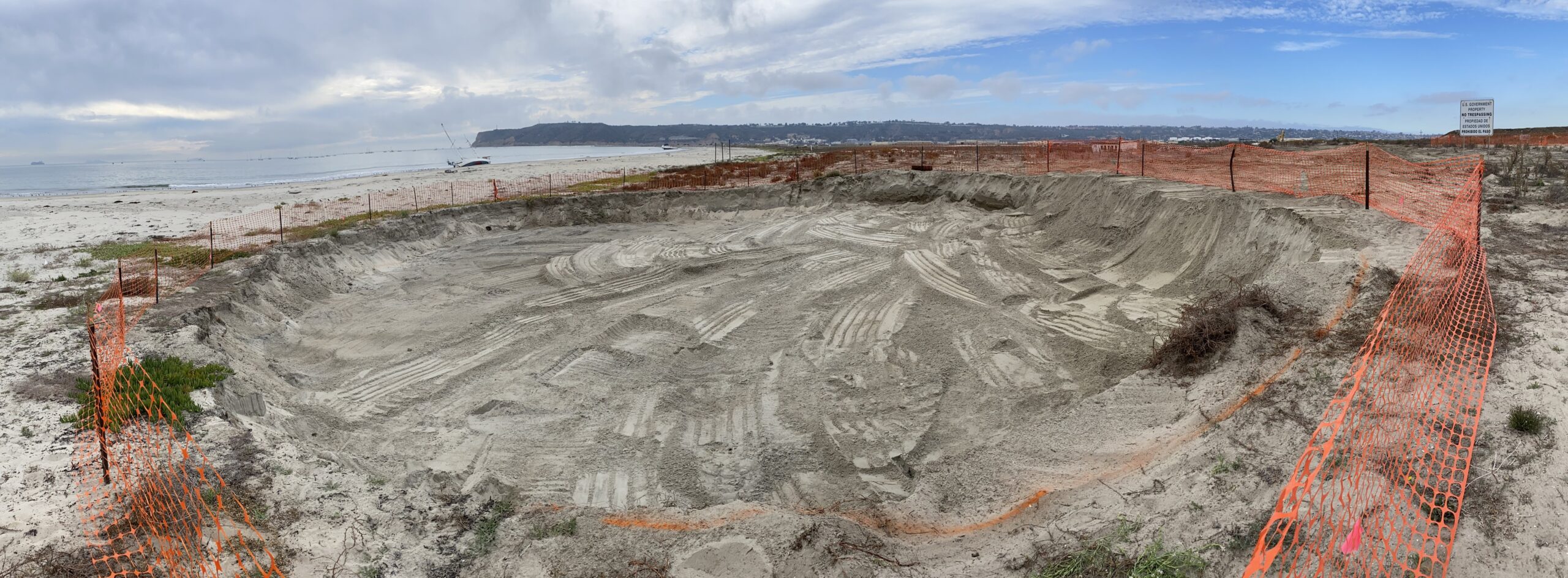 large sand hole dug near water