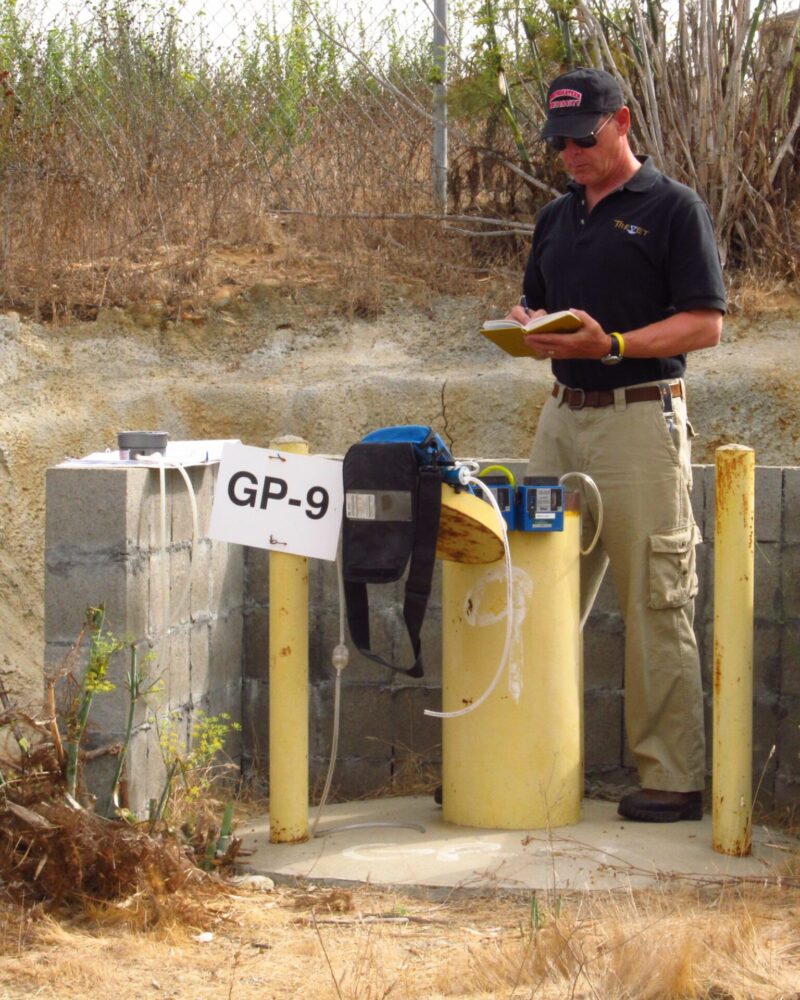Box Cyn LFG (6) person writing in book with equipment near walled off tubing area