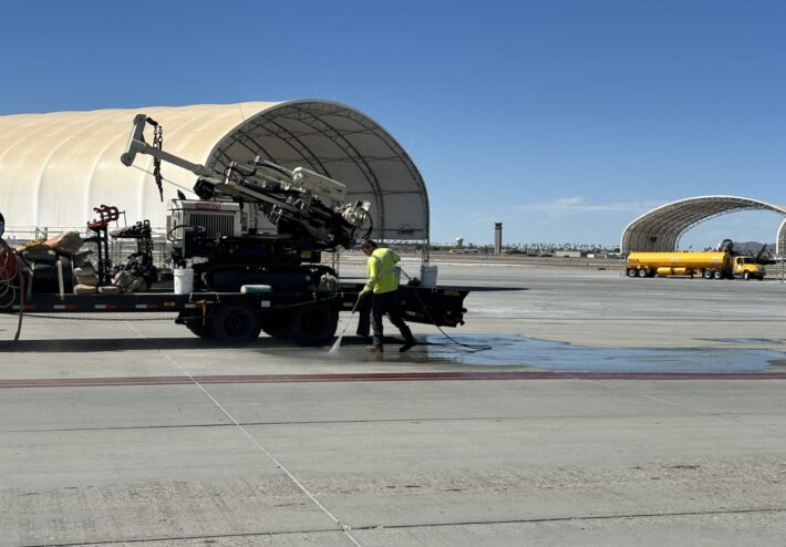 person using pressure washer on airfield