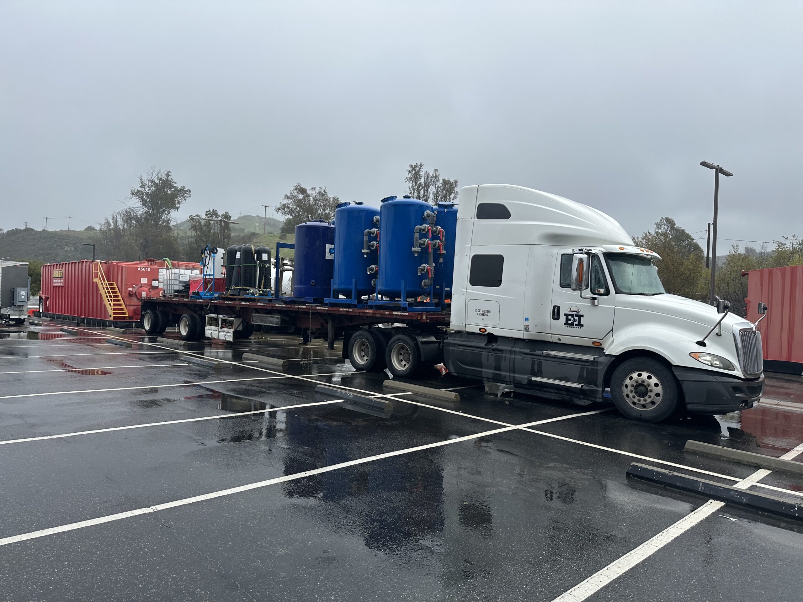 IMG_3771 large white semi truck with blue tank equipment in parking lot