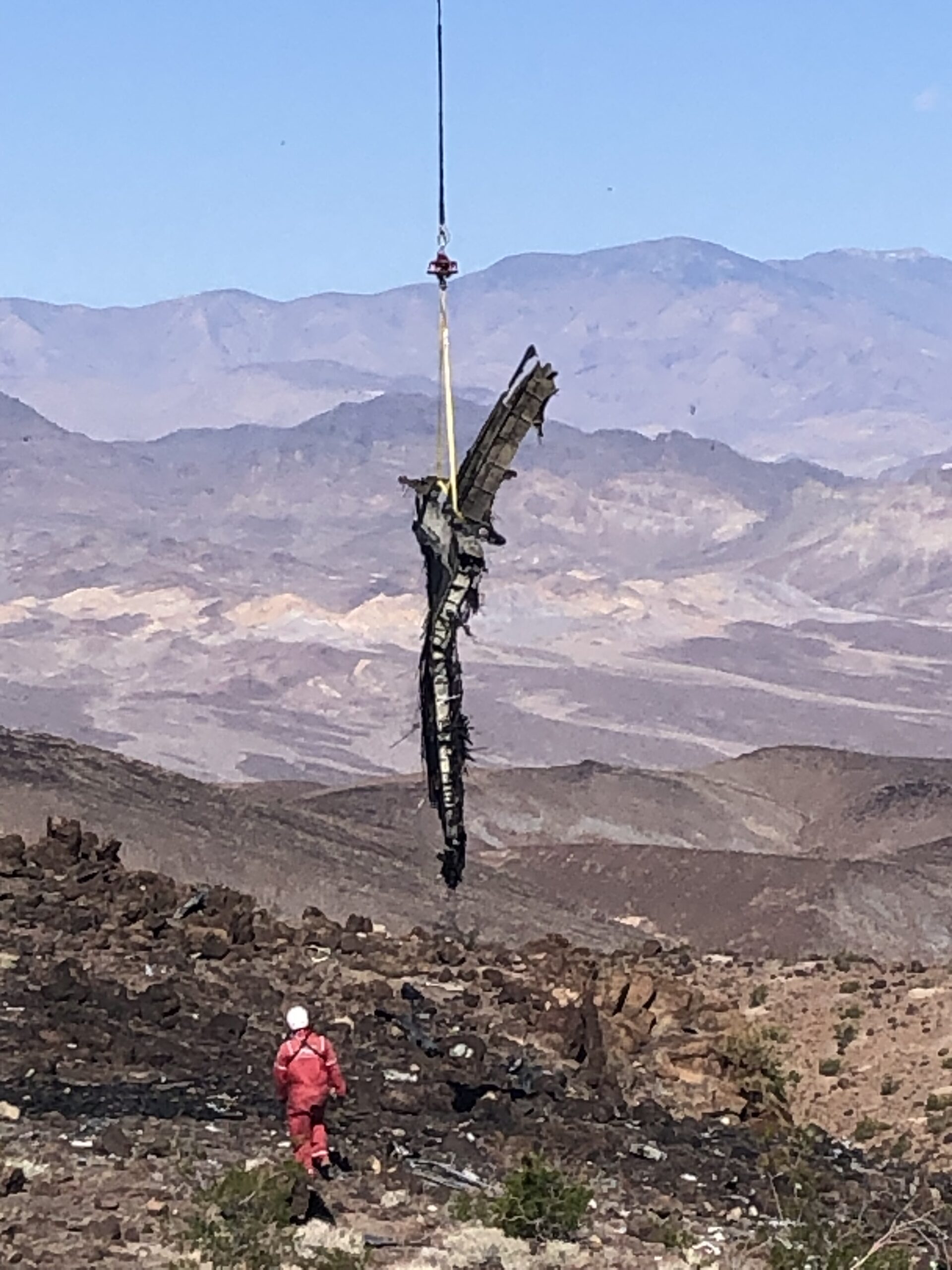 IMG_5426 pieces of rubble from aircraft being lifted with person in red walking near