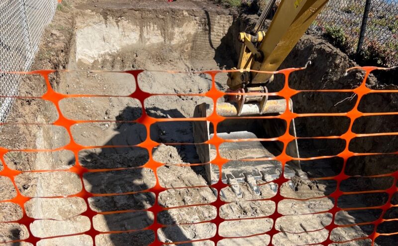 MRP 14 SA6 Excavation complete orange safety fence in front of excavator scoop bucket in dirt