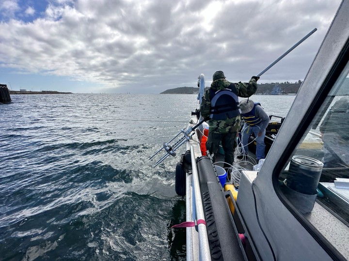 person holding a trident equipment on a boat