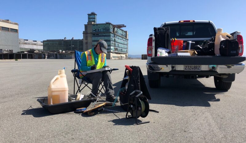 image2 person sitting in parking lot surrounded by equipment and a truck