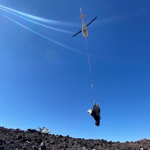 lift against sky helicopter lifting rubble away into the sky
