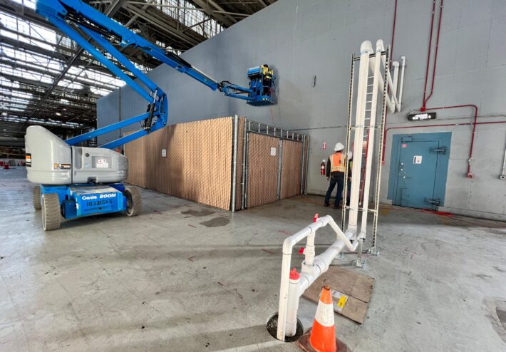 large boom lift in building with people working