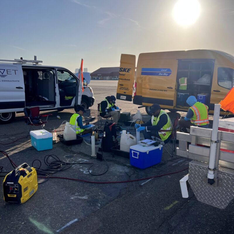 ou 11 sampling people sitting around equipment in a parking lot with vans